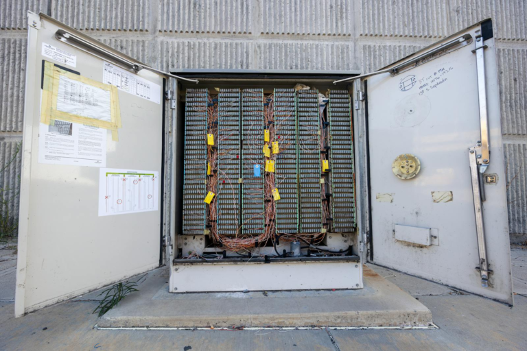 Open outdoor telephone junction box showing internal wiring and connectors.